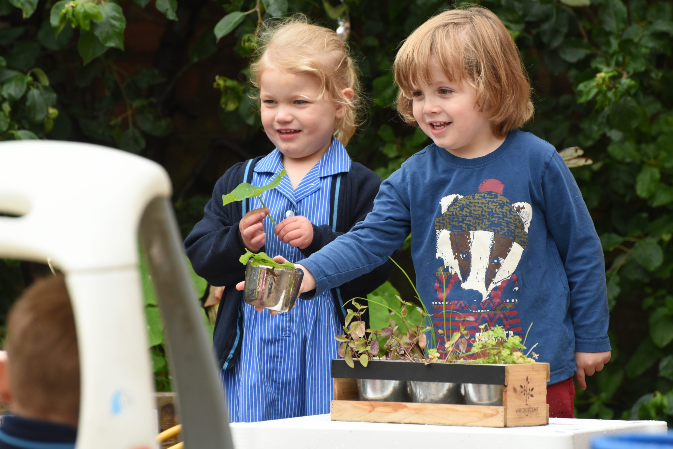starting nursery children playing outdoors with plants