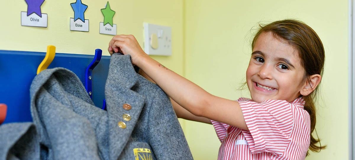 nursery admissions in Worcestershire child hanging blazer up on peg