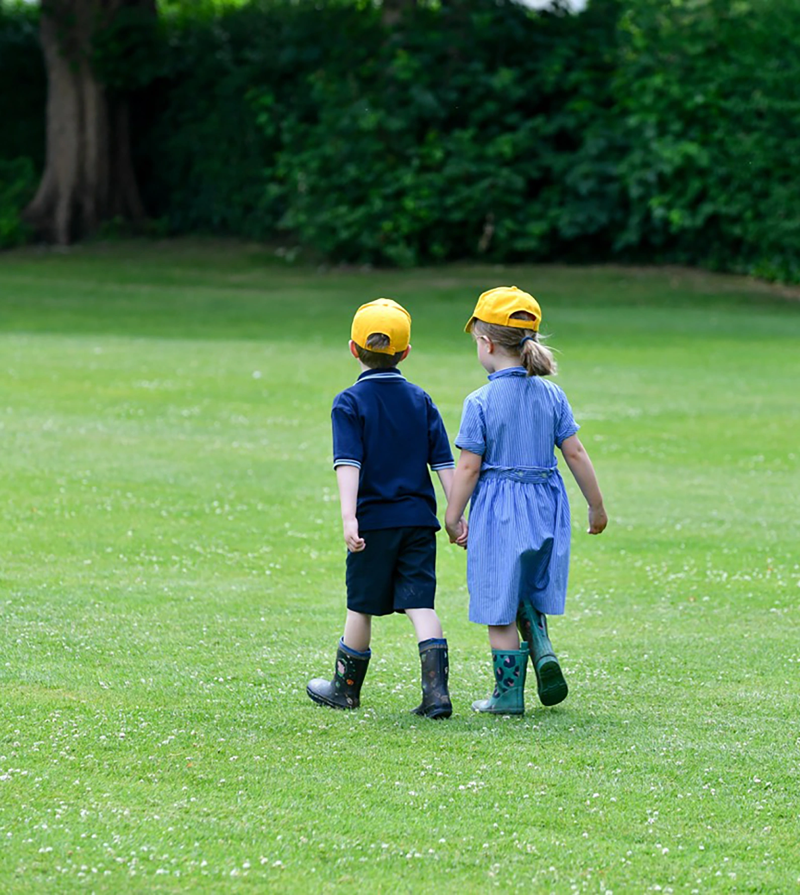 Springfield Nursery two children wearing welling walking on the field