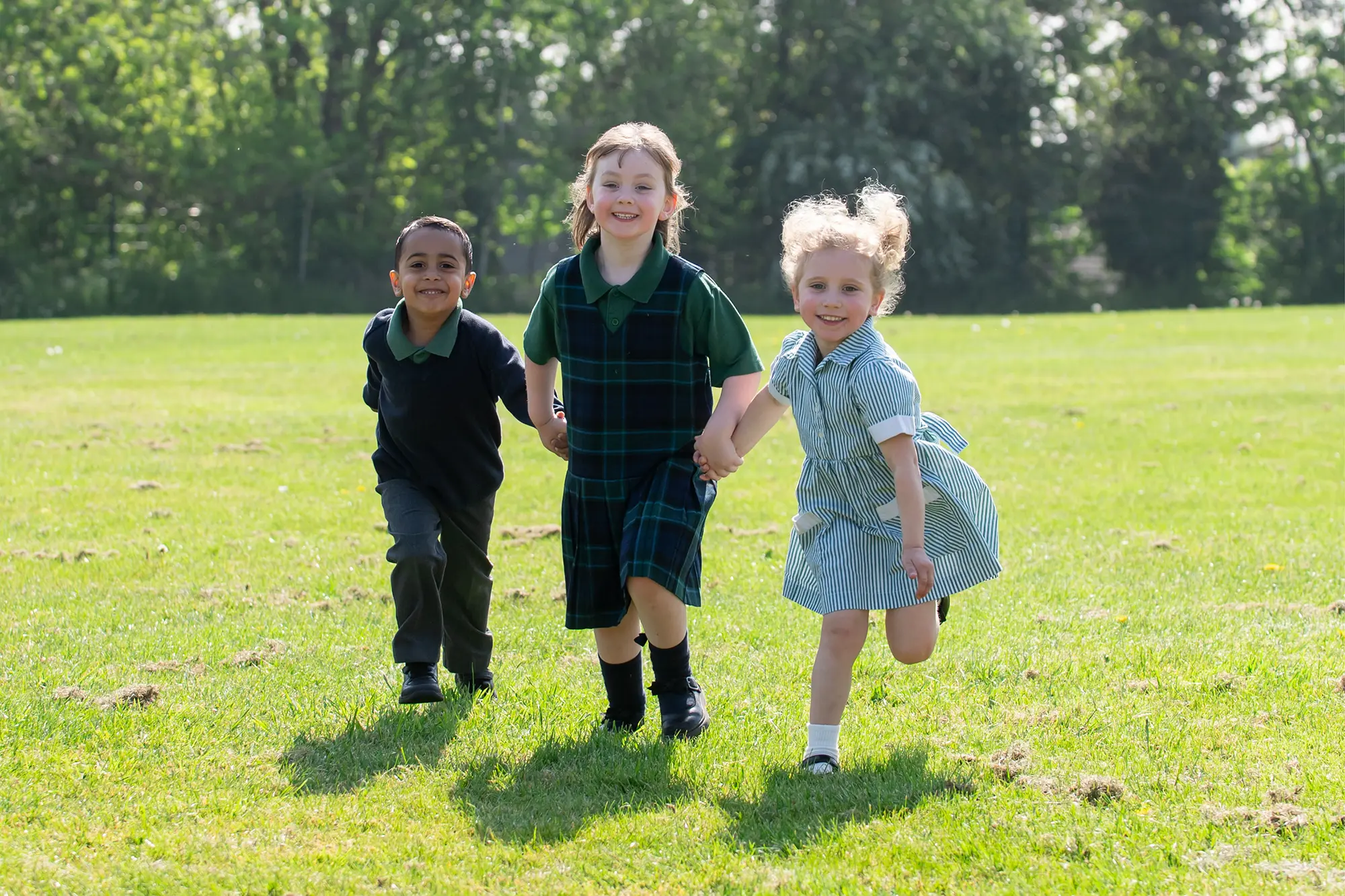 Dodderhill Nursery pupils playing on the field in the sunshine
